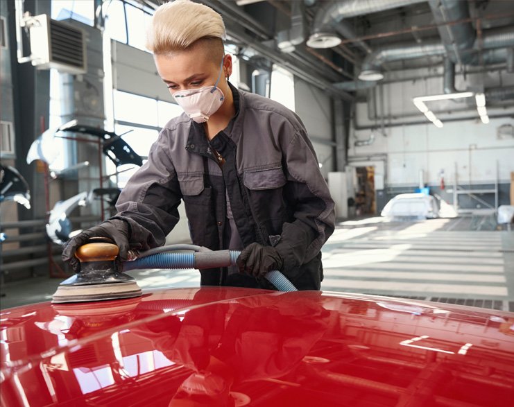 Worker sanding car body