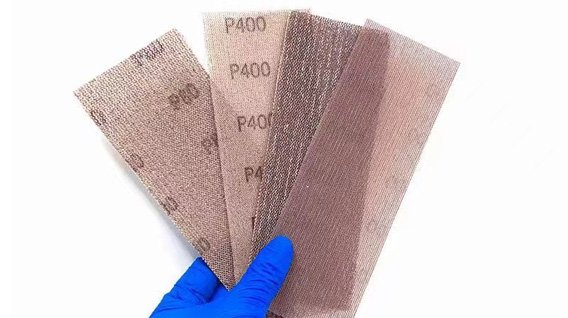 Hand holding various mesh abrasive grits