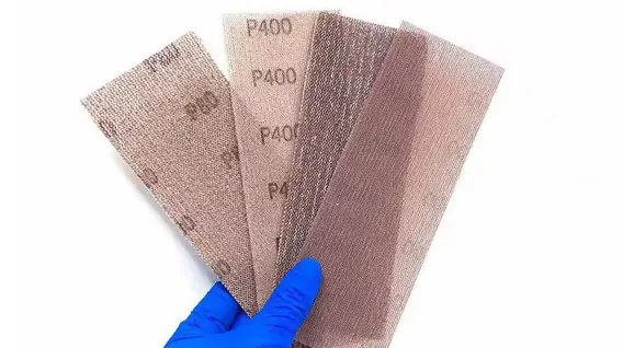 Hand holding various mesh abrasive grits